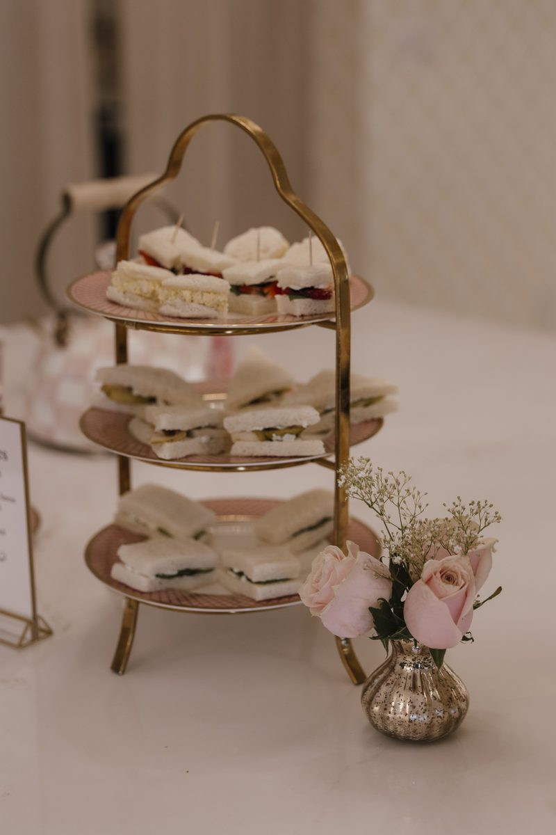 Tiered tray of finger sandwiches with pink roses at Tea Time at Monarch