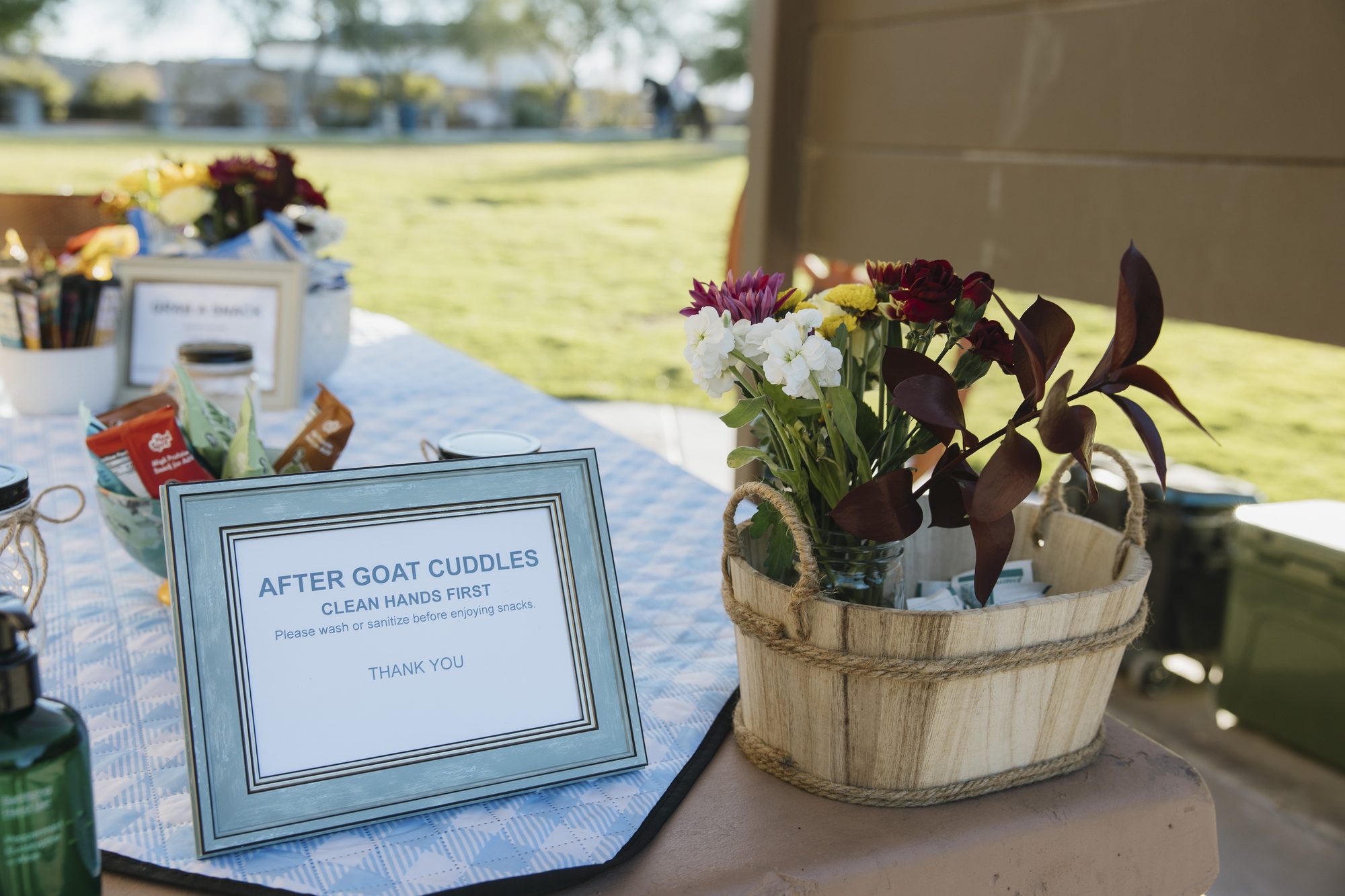 The goat yoga welcome table with flowers and an After Goat Cuddles sign