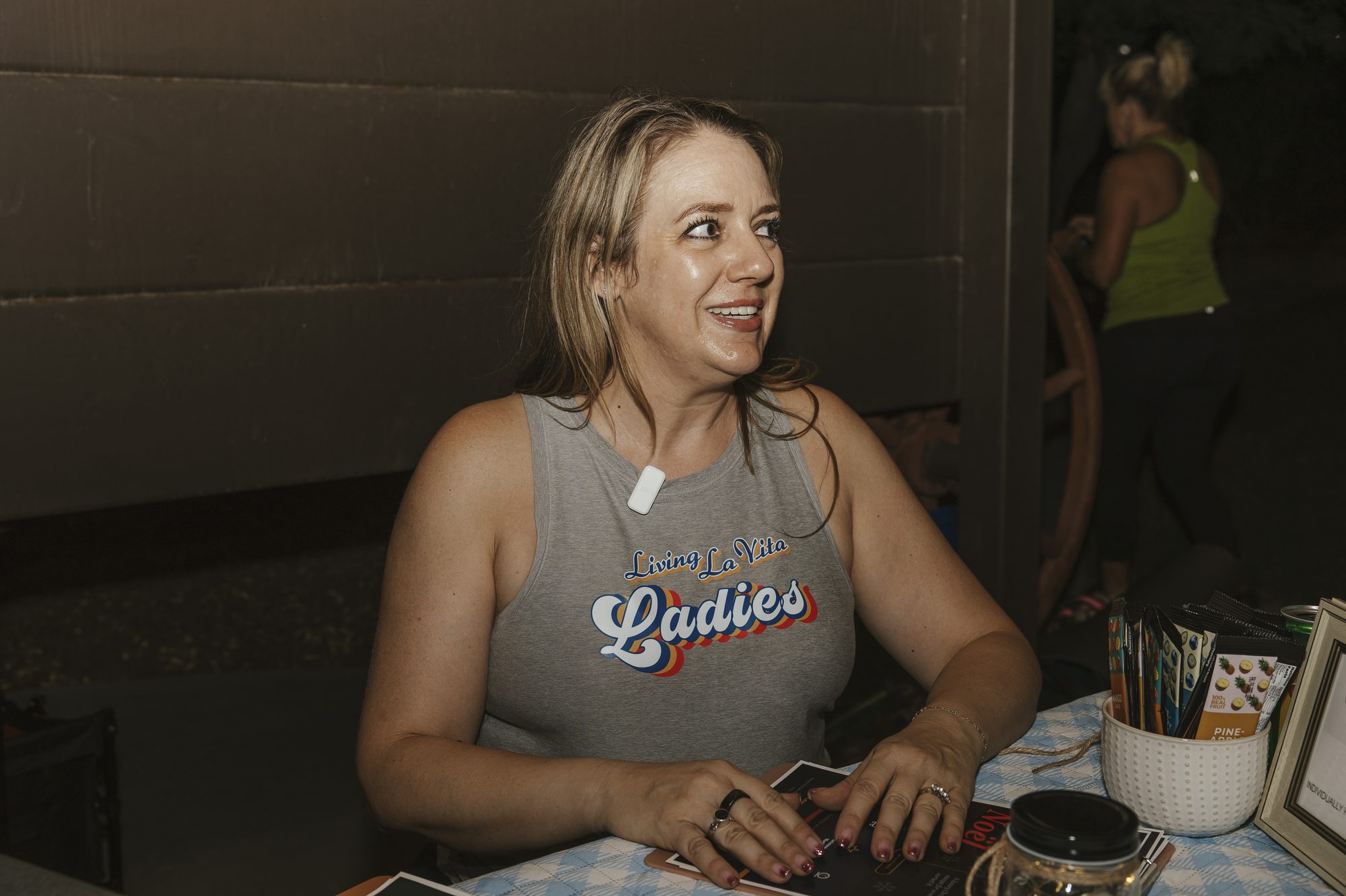 A woman smiles at the sips and nibbles table as the goat yoga evening winds down